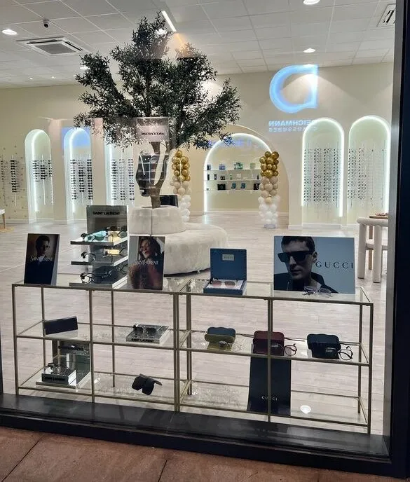 La vitrine des collections : présentoirs dorés, visuels Gucci et Saint Laurent