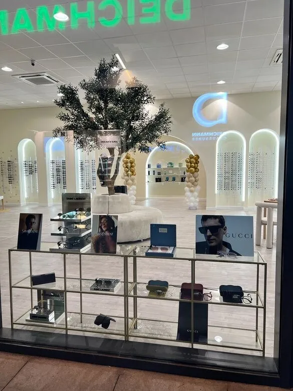 La vitrine des collections : présentoirs dorés, visuels Gucci et Saint Laurent